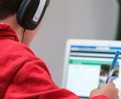 person in red shirt wearing black and gray headphones